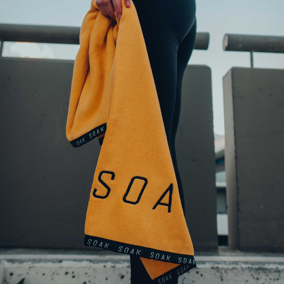 Female holding yellow gym sports towel